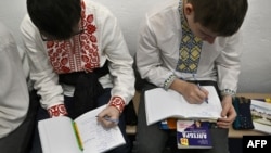 Дети занимаются в бомбоубежище в подвале школы после сигнала тревоги в Киеве, 23 марта 2023 года, фото AFP