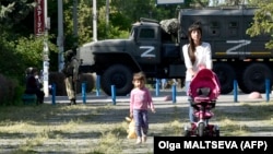 Жители оккупированной Россией части Херсонской области на фоне российской военной техники