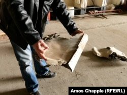 Член аэроклуба Миловице держит в руках обломки советского истребителя, который, по его словам, был взорван взрывчаткой во время вывода советских войск 35 лет назад.