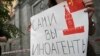 Russia -- A journalist holds a placard which reads "Foreign agents yourself" near the headquarters of Federal Security Service in Moscow