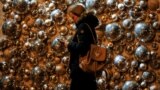 UKRAINE -- A woman uses her mobile phone as she walks past a shopping mall entrance with Christmas decorations in central Kyiv, November 29, 2017
