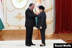 Президент Таджикистана Эмомали Рахмон вручает награду своей дочери Озоде, руководителю его администрации. Душанбе, 25 августа 2025 года