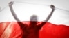 BELARUS -- Demonstrator is silhouetted by an old Belarusian national flag during a rally in Minsk, Belarus, Sunday, Oct. 4, 2020. 